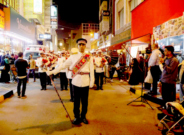 <p><em><strong>The band performing for onlookers</strong></em></p><div class="explain-selected-button explain-selected-circle"></div><style>
.explain-selected-button.explain-selected-text-selected-show-button {
  display: block !important;
}

.explain-selected-button.explain-selected-expanded {
  width: 400px;
  border: 0px;
  cursor: default; 
  height: 350px; 
  overflow: auto;
  box-shadow: rgba(15, 15, 15, 0.05) 0px 0px 0px 1px, rgba(15, 15, 15, 0.1) 0px 3px 6px, rgba(15, 15, 15, 0.2) 0px 9px 24px;
}

.explain-selected-button.explain-selected-circle:not(.explain-selected-expanded) {
  width: 35px;
  height: 35px;
  background: transparent;
  border-radius: 50%;
  opacity: 0.5;
}
.explain-selected-button.explain-selected-circle:not(.explain-selected-expanded):hover::before {
  content: "";
  position: absolute;
  width: 35px;
  height: 35px;
  background-color: rgba(128, 0, 128, 0.5);
  border-radius: 50%;
  top: 50%;
  left: 50%;
  transform: translate(-50%, -50%);
  animation: explain-selected-growAndFade 2.0s ease-in-out;
  animation-iteration-count: infinite;
}

.explain-selected-button.explain-selected-circle:not(.explain-selected-expanded)::after {
  content: "";
  position: absolute;
  width: 10px;
  height: 10px;
  background-color: rgb(128, 0, 128);
  top: 50%;
  left: 50%;
  transform: translate(-50%, -50%);
  border-radius: 50%;
}
.explain-selected-button.explain-selected-circle:not(.explain-selected-expanded):hover::after {
  width: 14px;
  height: 14px;
}

@keyframes explain-selected-growAndFade {
  0% {
    width: 10px;
    height: 10px;
    opacity: 1;
  }
  100% {
    width: 30px;
    height: 30px;
    opacity: 0;
  }
}

.explain-selected-button {
  display: none !important;
  width: 120px;
  height: 28px;
  border-radius: 4px;
  border: 0px;
  position: absolute;
  z-index: 9999;
  opacity: 1;
  cursor: pointer;
  background: white;
  text-align:left;
  font-family: Tahoma,Arial,Helvetica Neue,Helvetica,sans-serif; 
  background-color: #fff;
  color: #333;
}

.swal2-icon-show-explainselected {
  border: none;
}

.swal2-container p {
  margin: 0 !important;
}

</style>